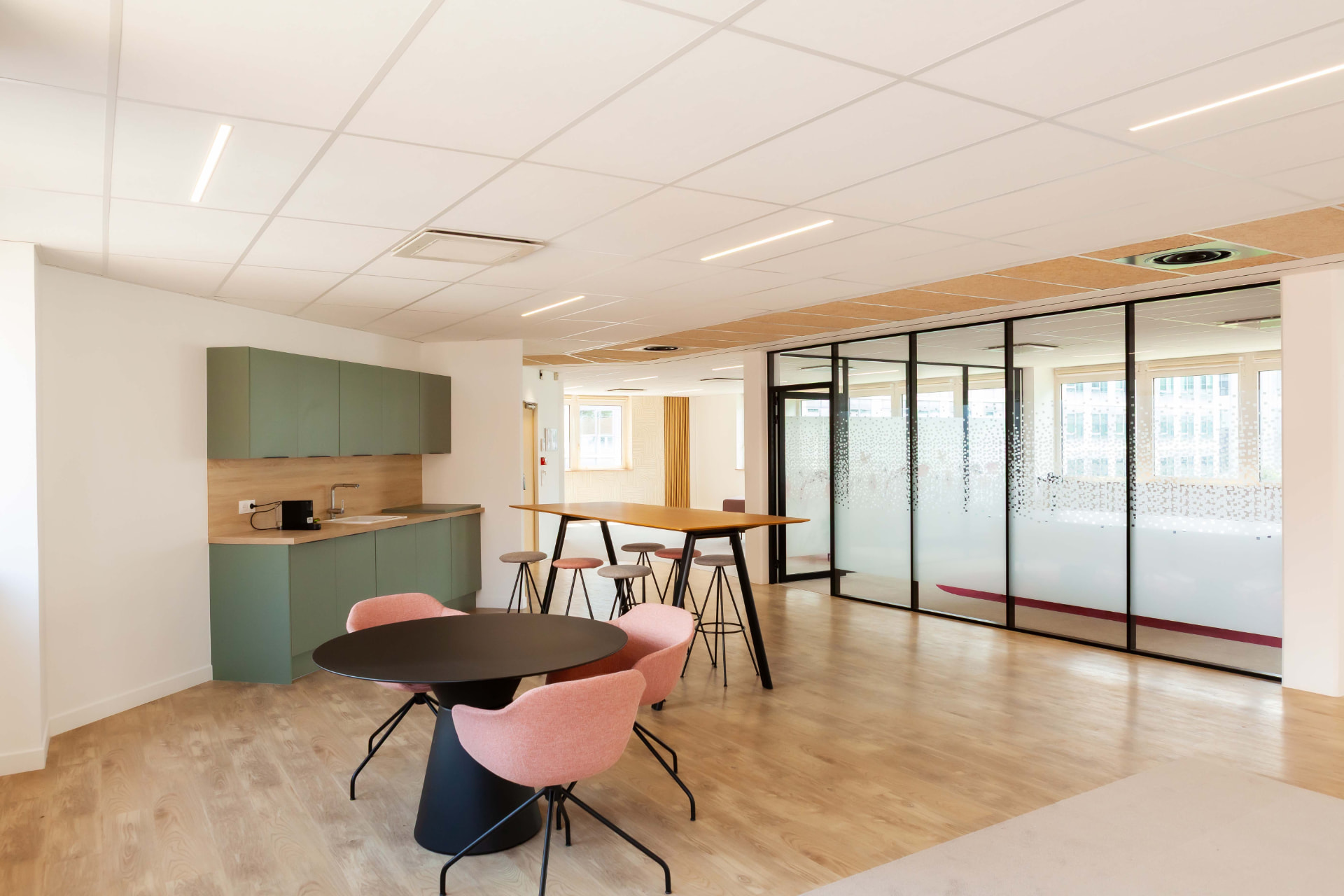 CLS Inside — pink chairs around a round table with a glass-walled meeting room beyond