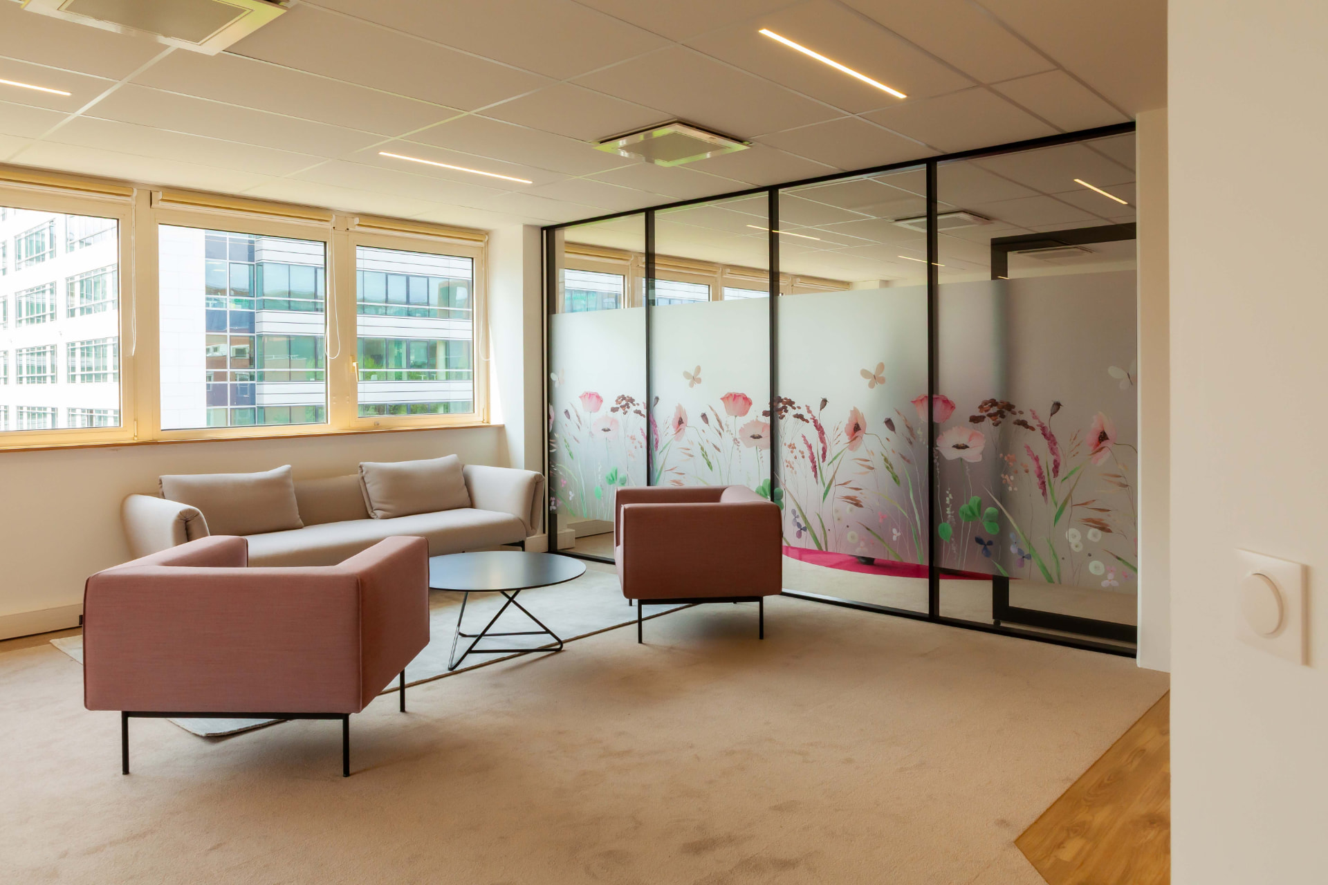 CLS Inside — lounge with beige sofa and pink armchairs beside floral-motif glass screens
