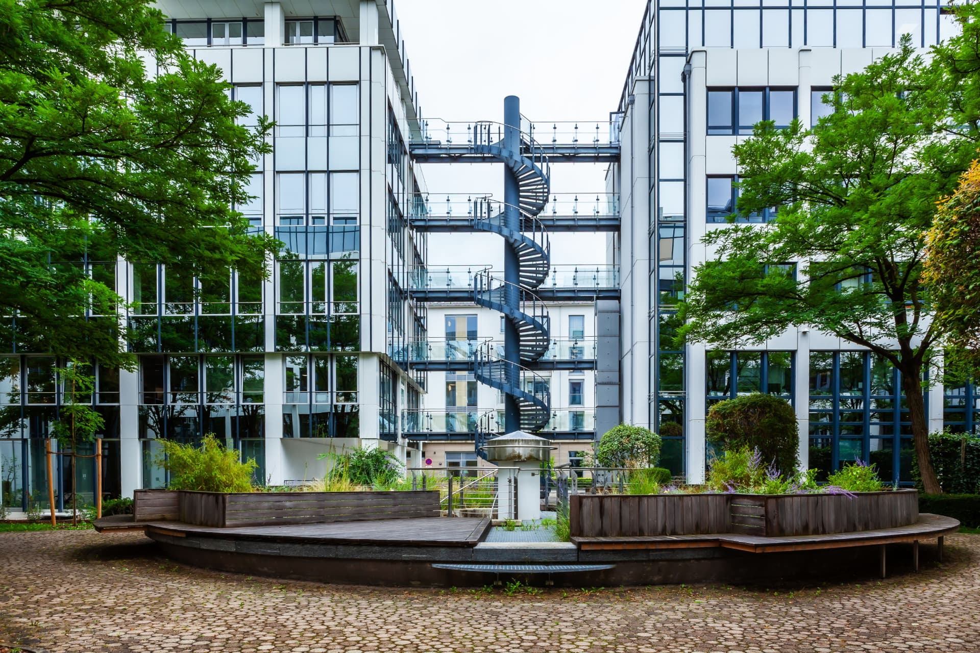 CLS Maximilianforum — glass office buildings with spiral staircase and landscaped courtyard in Munich